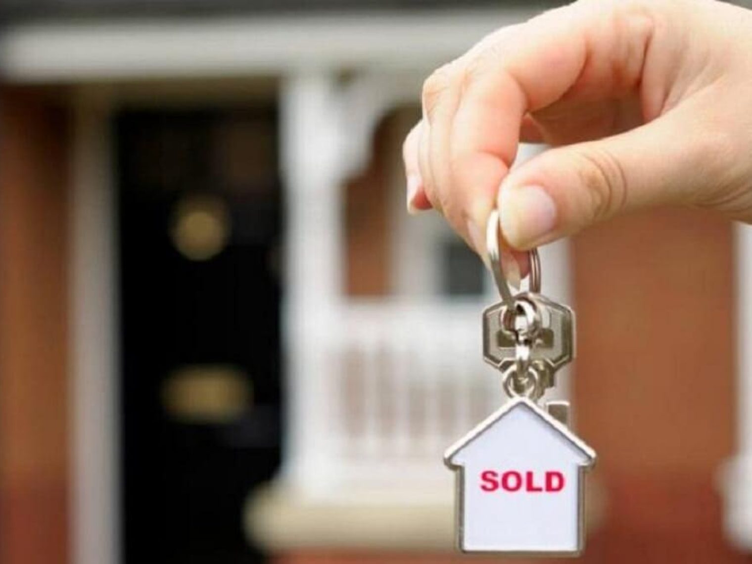 Keyring in the shape of a house with the word SOLD in red letters.