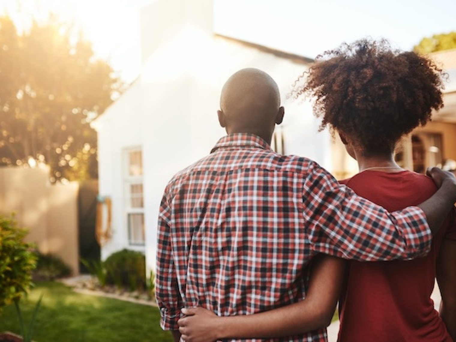 Rear view of a man and woman viewing a house.